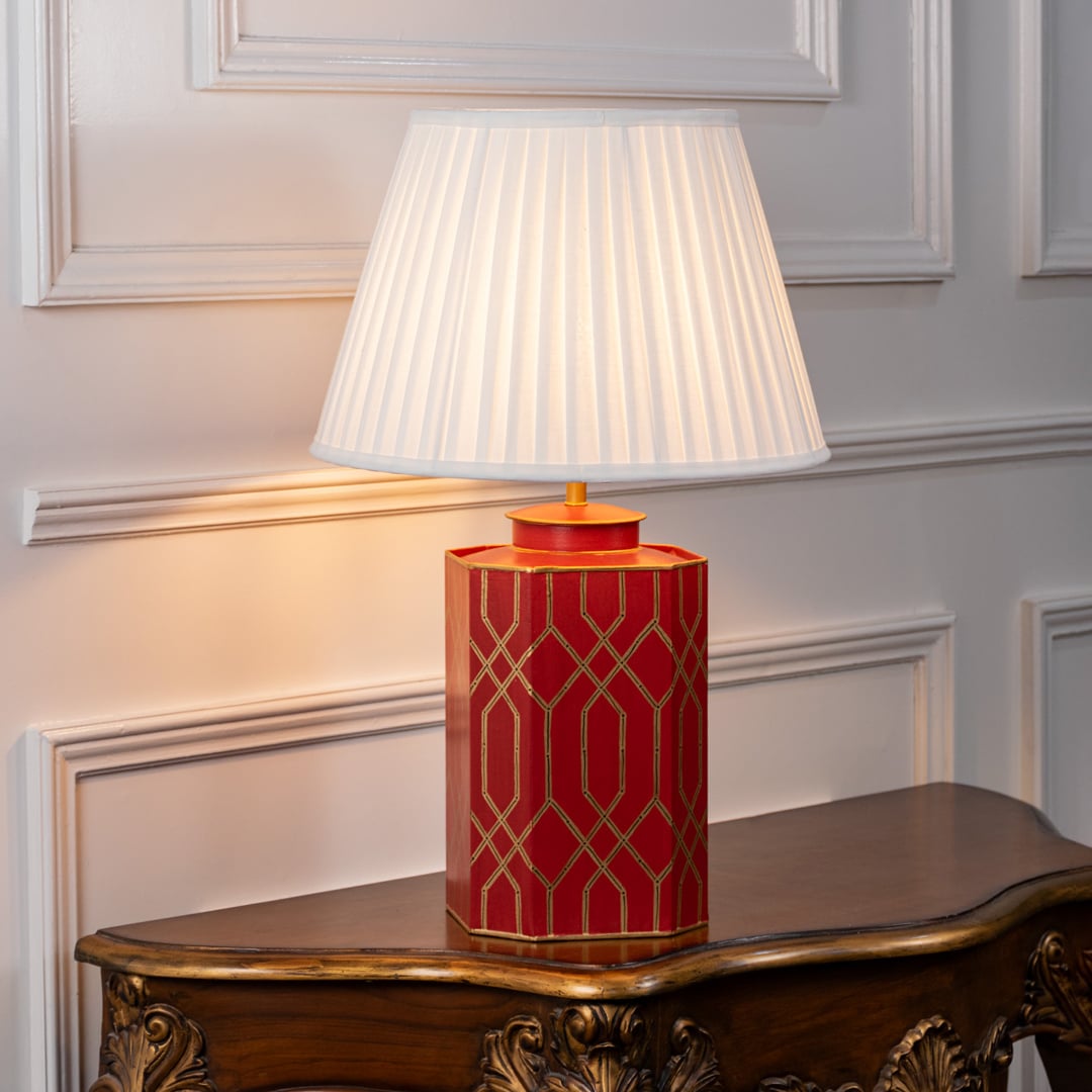 Decorative table lamp showcasing white fabric shade and red ceramic base with elegant geometric gold pattern for classic interiors.