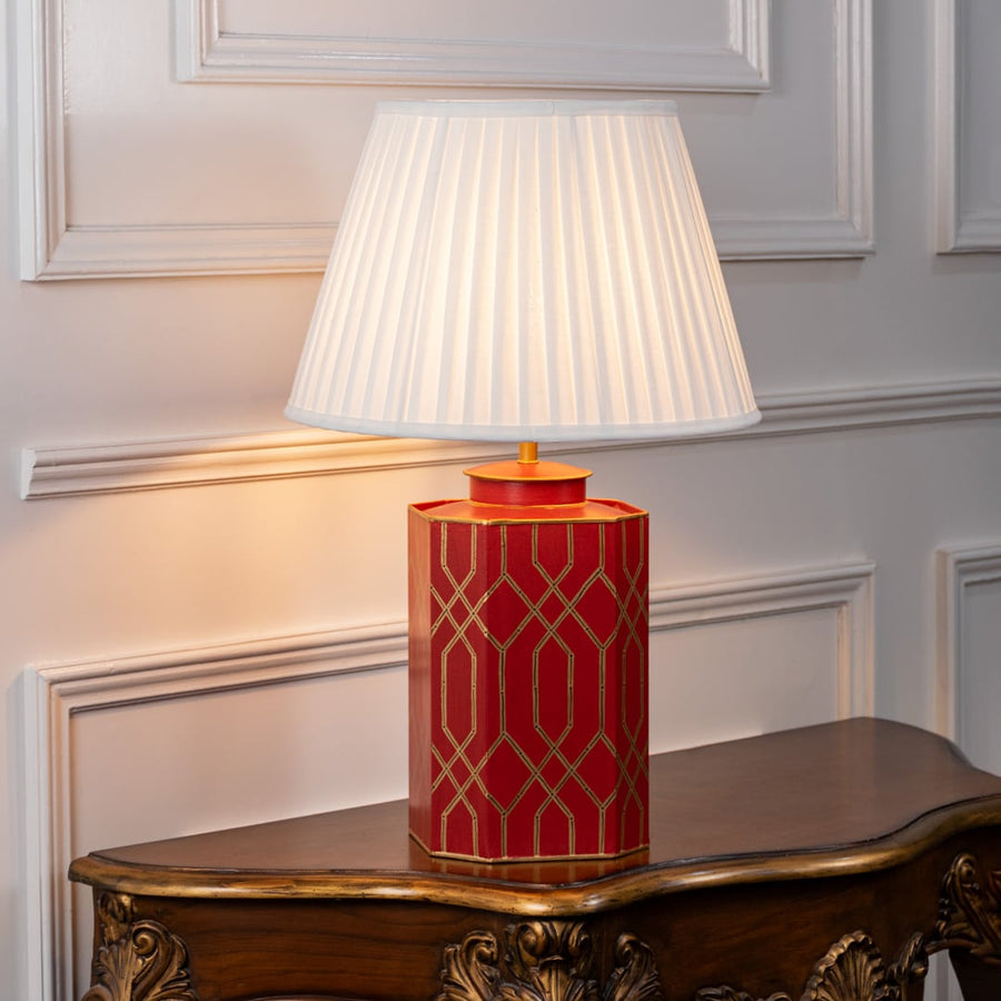 Decorative table lamp showcasing white fabric shade and red ceramic base with elegant geometric gold pattern for classic interiors.