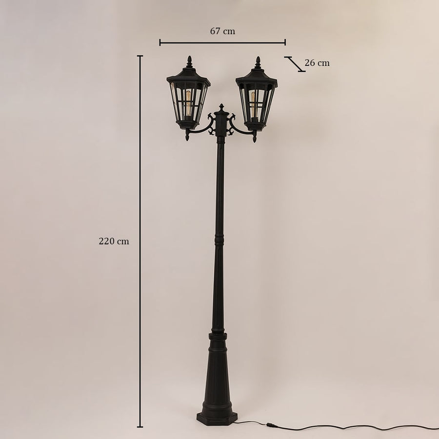 Black outdoor street lamp with dual heads shown with dimensions 220 cm height 67 cm width and 26 cm depth.