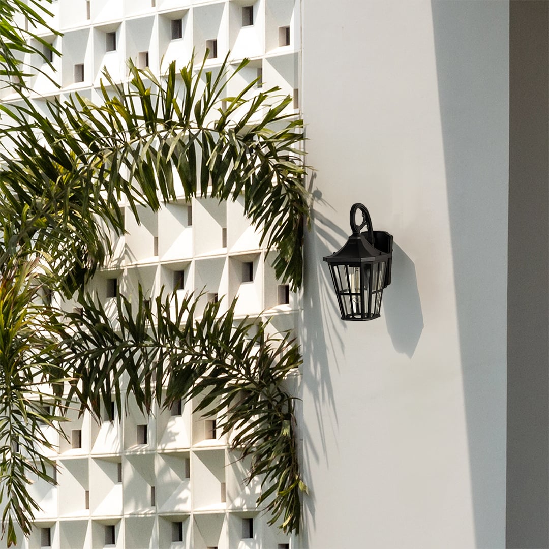 Black metal outdoor lantern fixed on a bright exterior wall enhancing outdoor decor with soft warm light for pathways and entrances.