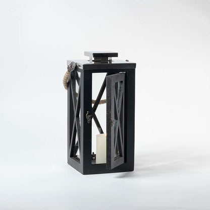 Black wooden lantern with clear glass panels and rope handle for farmhouse tabletop decor styling.
