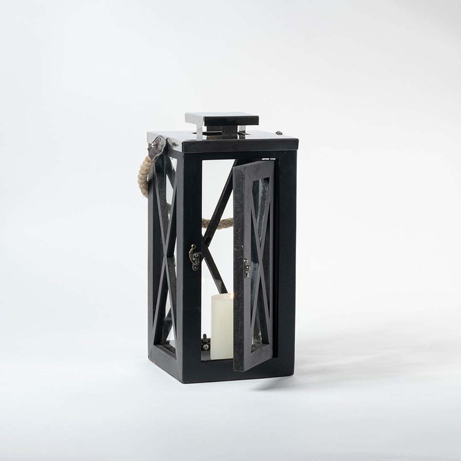 Black wooden lantern with clear glass panels and rope handle for farmhouse tabletop decor styling.
