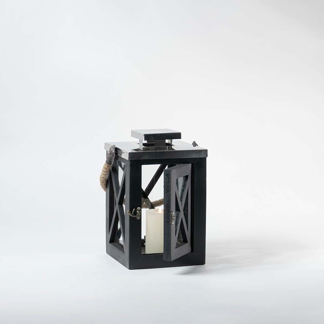 Black lantern on a white background highlighting its metal structure with glass panels and natural rope handle detail.