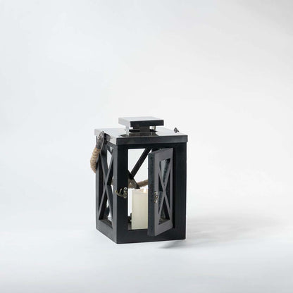 Black lantern on a white background highlighting its metal structure with glass panels and natural rope handle detail.