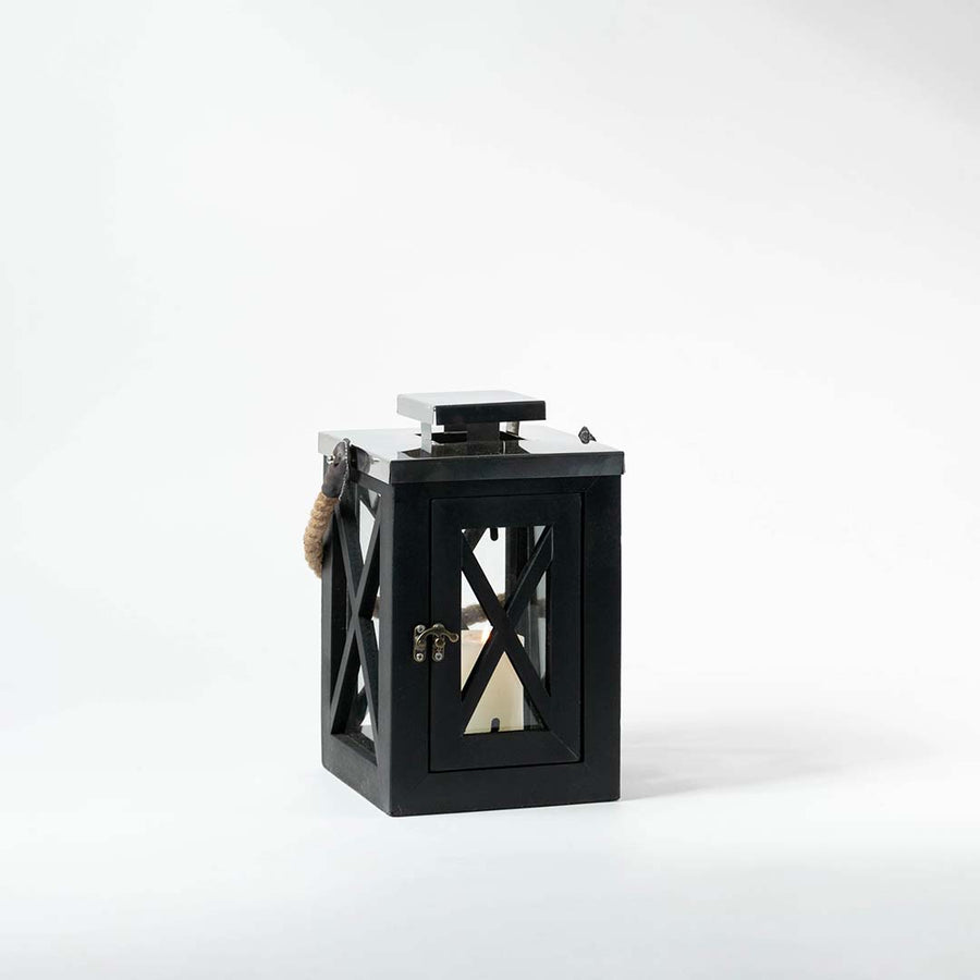 Black metal lantern with glass panels and candle holder displayed on white background ideal for indoor and outdoor decor styling.