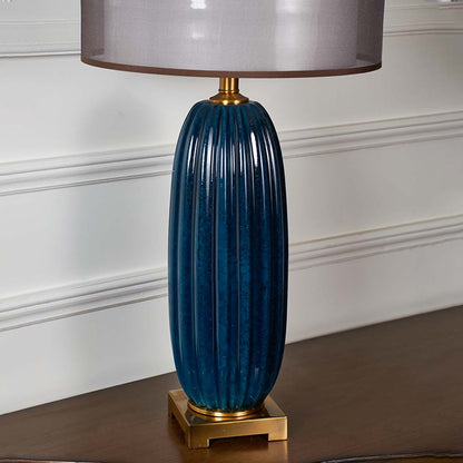 Blue ribbed glass table lamp with brass base designed for elegant modern decor and ambient lighting indoors.