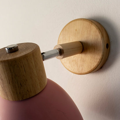 Modern pink wall light with wooden accents and matte finish for stylish contemporary interior decor.