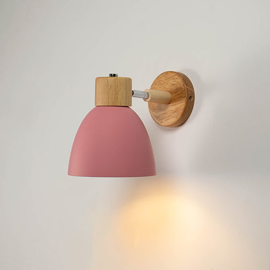 Illuminated modern pink wall light with wooden accents against a plain white background highlighting the warm LED glow and matte finish.