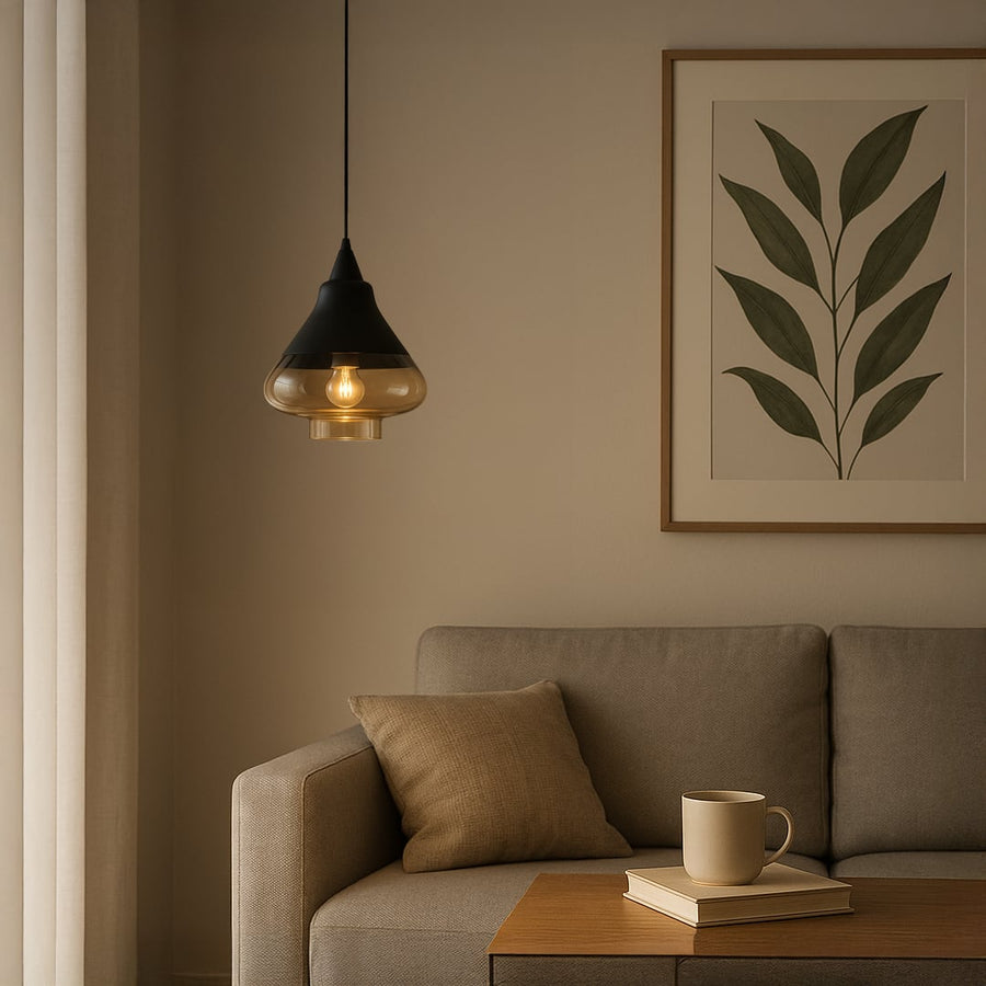 Amber glass pendant light glowing warmly in a modern living room with beige sofa framed leaf artwork and soft neutral decor.