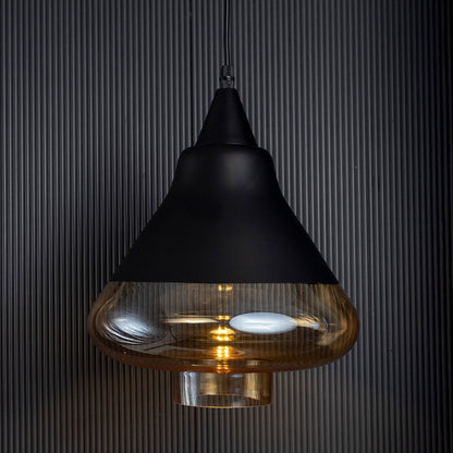 Amber glass pendant light turned off glowing through golden tinted glass against a dark ribbed background.