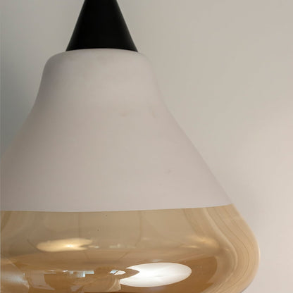 Closeup of amber glass pendant light with smooth white and golden glass surface showcasing modern craftsmanship.