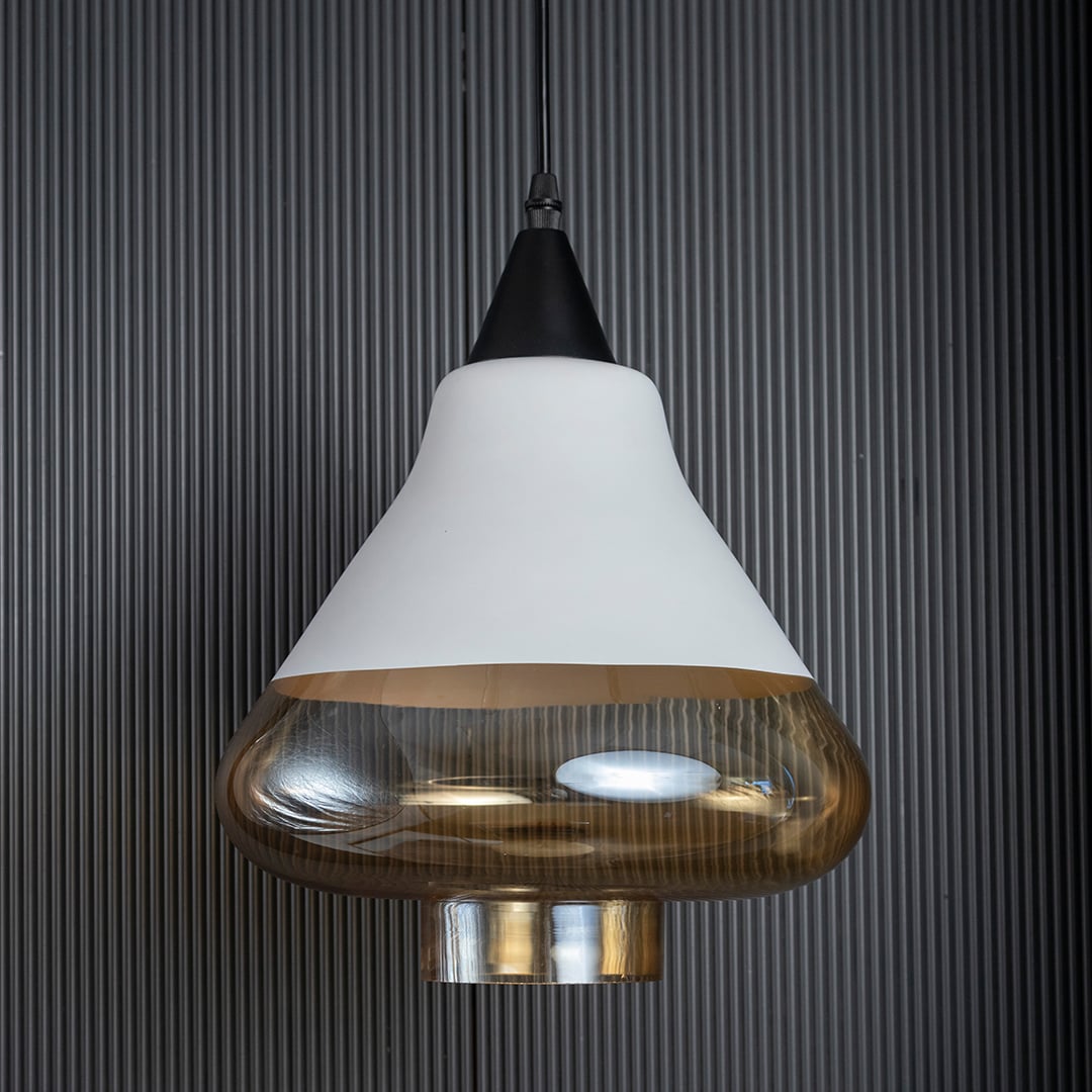 Amber glass pendant light with white matte top and golden glass bottom displayed against a black ribbed background.