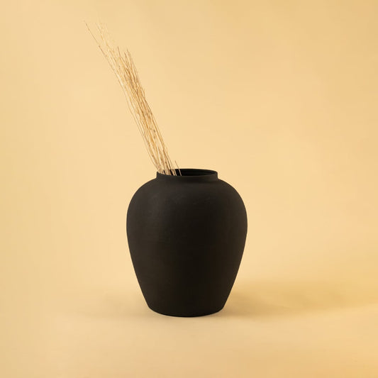 Black textured metal vase styled in a warm minimal setup adding bold modern elegance to contemporary home decor.