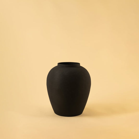 Black modern metal vase displayed on a clean white background highlighting its textured finish and sculptural silhouette.