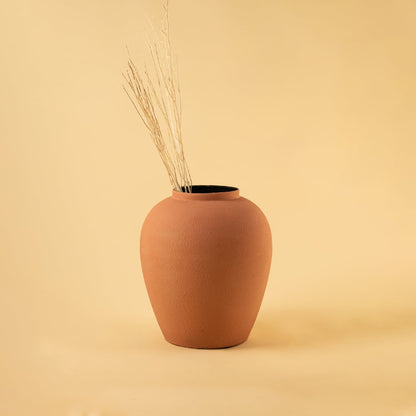 Terracotta textured metal vase styled in a warm minimal scene adding earthy modern charm to contemporary home decor.