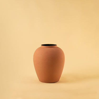 Sophisticated matte terracotta rounded metal vase for modern home decor and clean minimalist interior styling.