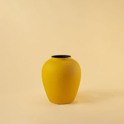 Yellow modern metal vase displayed on a clean white background highlighting its textured surface and sculpted form.