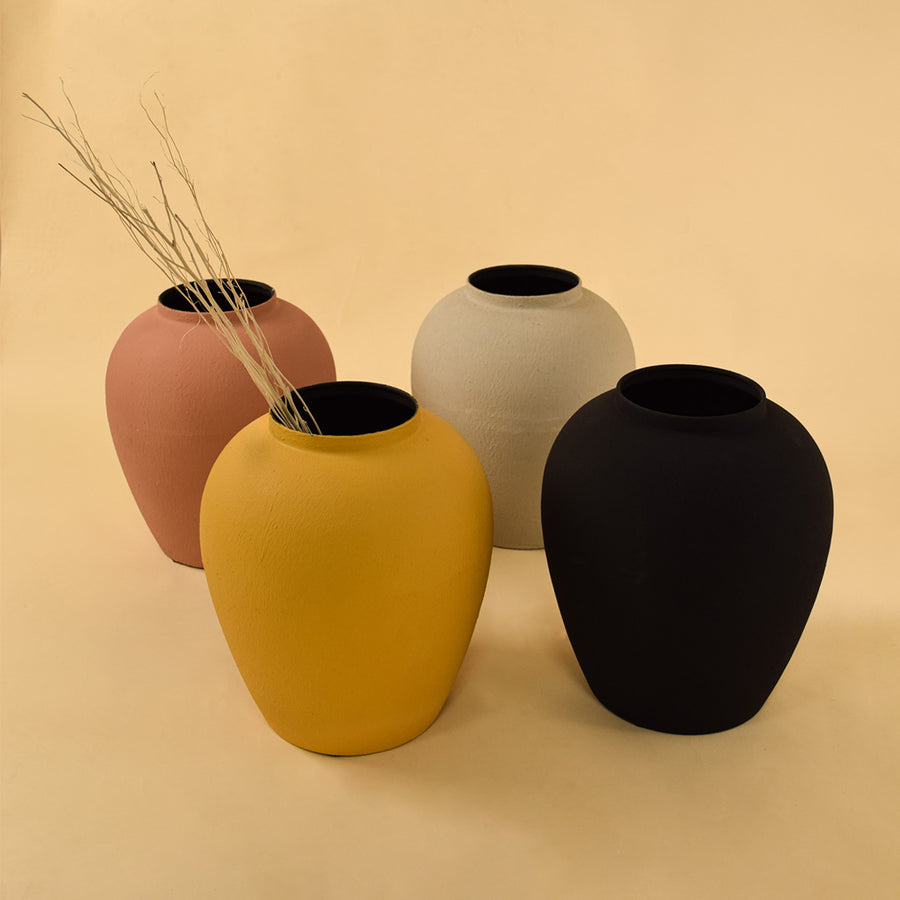 Collection of colorful matte rounded metal vases for vibrant modern home decor and artistic tabletop centerpiece design.