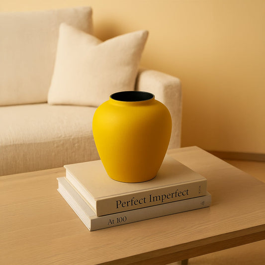 Yellow textured metal vase styled in a warm minimal scene adding bold modern charm to contemporary home decor.