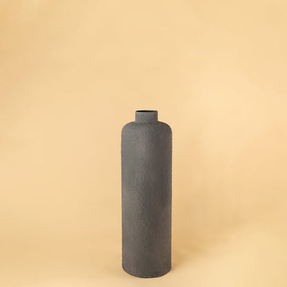 Grey tall handcrafted vase placed on a plain whte background highlighting its long cylindrical form and subtle texture for a minimal modern style.