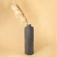 Grey tall textured vase styled with soft beige pampas placed against a warm neutral backdrop creating a minimal lifestyle look with a clean modern feel.