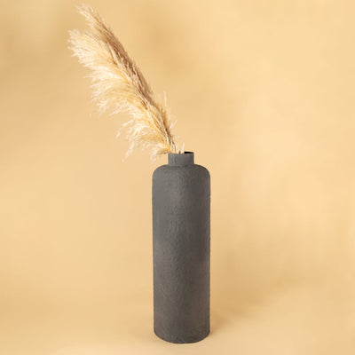 Grey tall textured vase styled with soft beige pampas placed against a warm neutral backdrop creating a minimal lifestyle look with a clean modern feel.