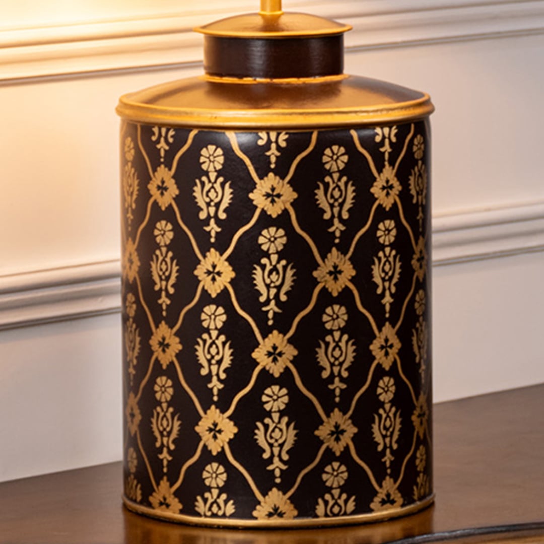 Table lamp closeup showcasing intricate black and gold pattern on ceramic base with detailed craftsmanship and glossy surface.