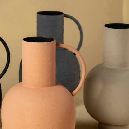 Detailed view of the grey textured jug vase capturing its rugged handcrafted surface tall cylindrical mouth and rounded base with a single stem placed inside.