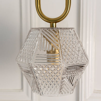 Closeup of geometric crystal pendant light with gold frame showcasing intricate craftsmanship and brilliance.