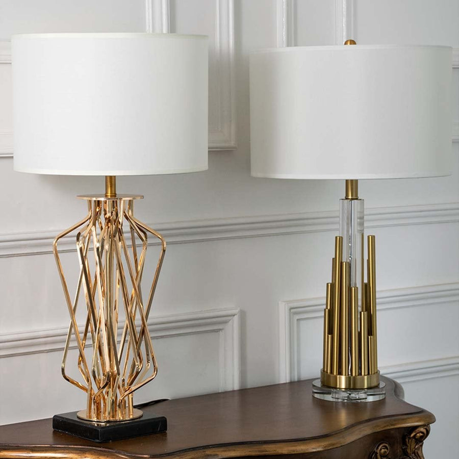 Gold sculpted table lamps with white drum shades shown together with lights off highlighting artistic bases and refined modern design for upscale decor.