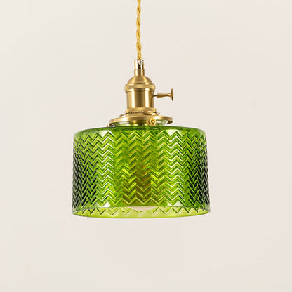 Closeup of green glass pendant light showing fine chevron texture and brass holder for premium decorative lighting.
