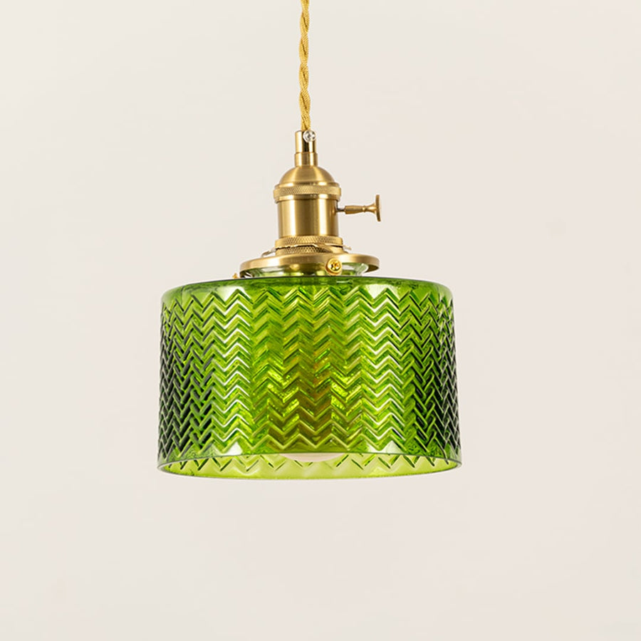 Closeup of green glass pendant light showing fine chevron texture and brass holder for premium decorative lighting.