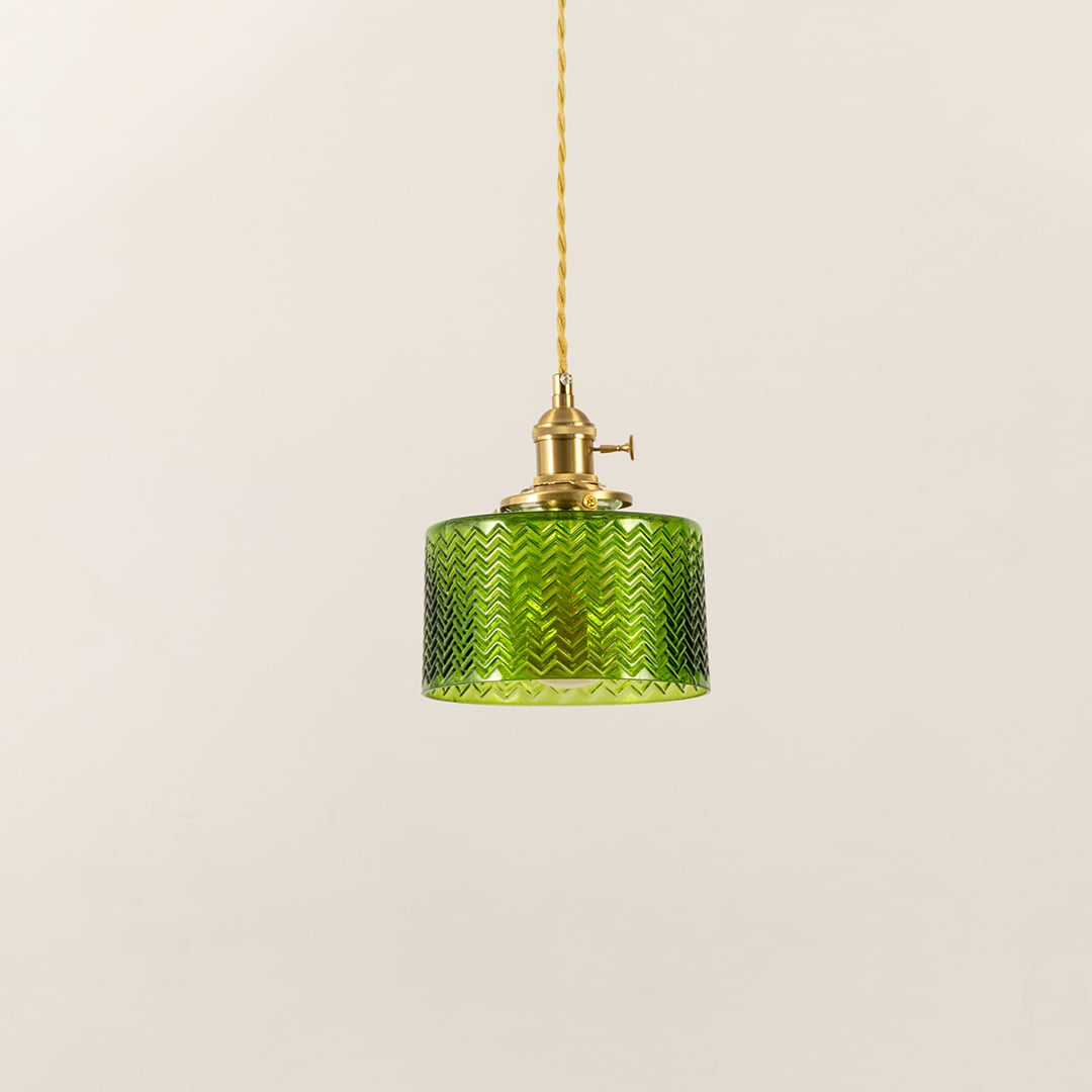 Unlit green glass pendant light with brass holder and twisted cord displayed on white background for modern decor.