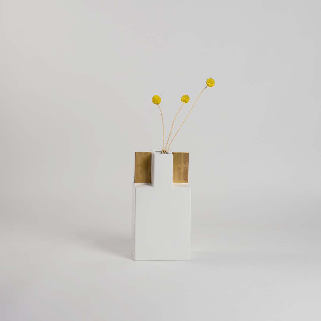 Contemporary white vase accented with gold panels  set against a bright white background for a crisp  elegant and modern visual appeal.