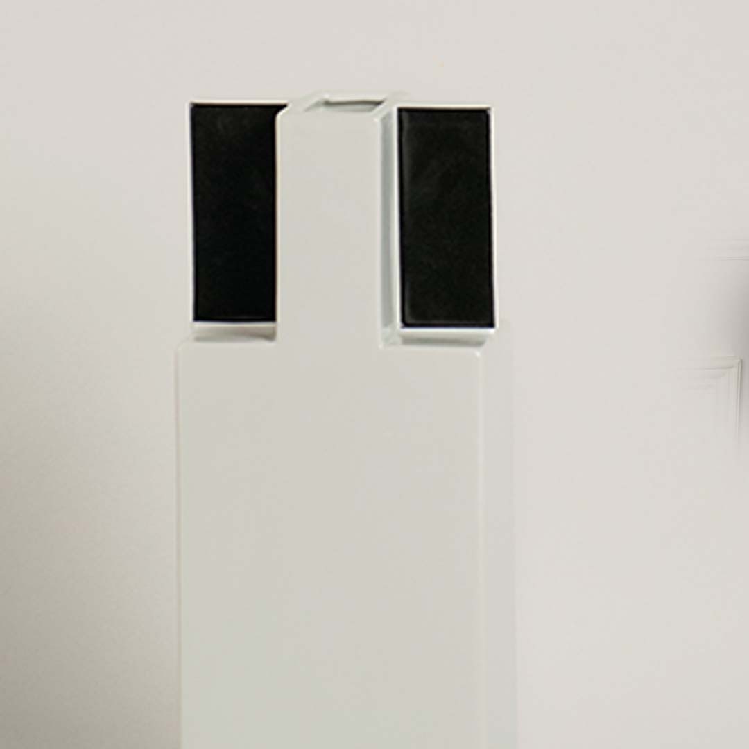 Closeup of ceramic vase in white with black square top showing modern minimal design perfect for home decor accent.