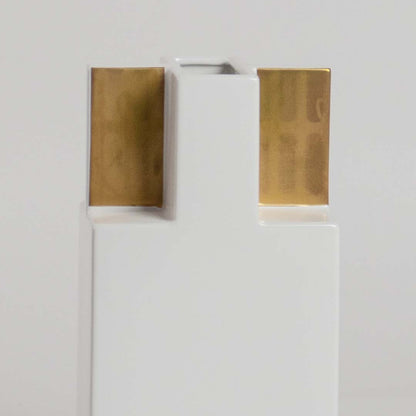 Closeup view of the white ceramic vase with gold top panels  showing its smooth finish  sharp structure  and elegant geometric form.