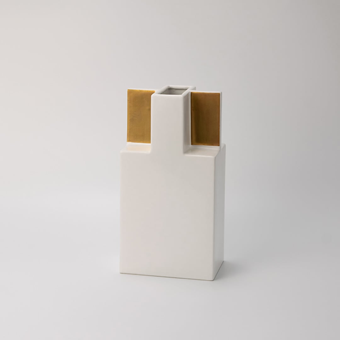 Minimal white ceramic vase with metallic gold accents captured on a bright white backdrop  emphasizing its clean lines and stylish build.