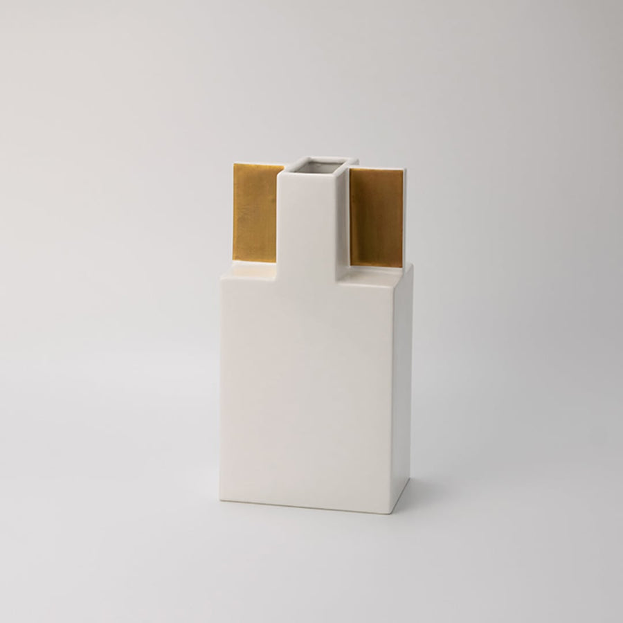 Minimal white ceramic vase with metallic gold accents captured on a bright white backdrop  emphasizing its clean lines and stylish build.