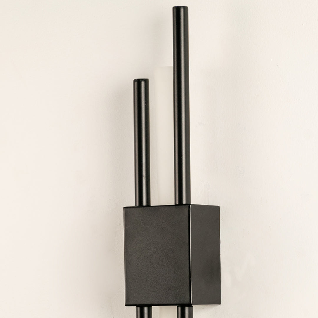 Closeup of modern black metal wall light with dual rod design for elegant bedroom hallway and living room wall decor.