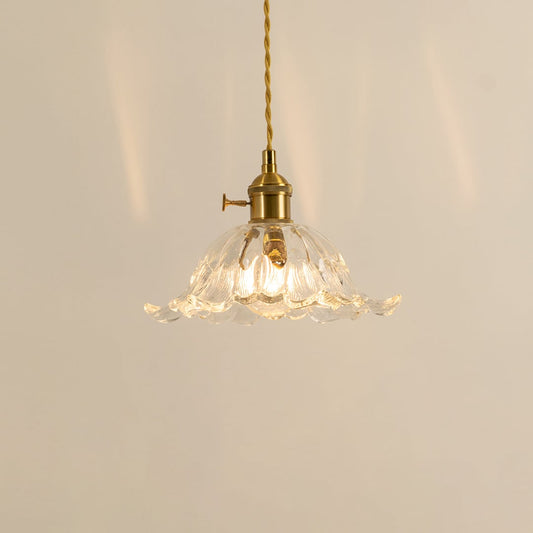 Clear glass and brass metal pendant light creating cozy ambience in stylish modern dining spaces.
