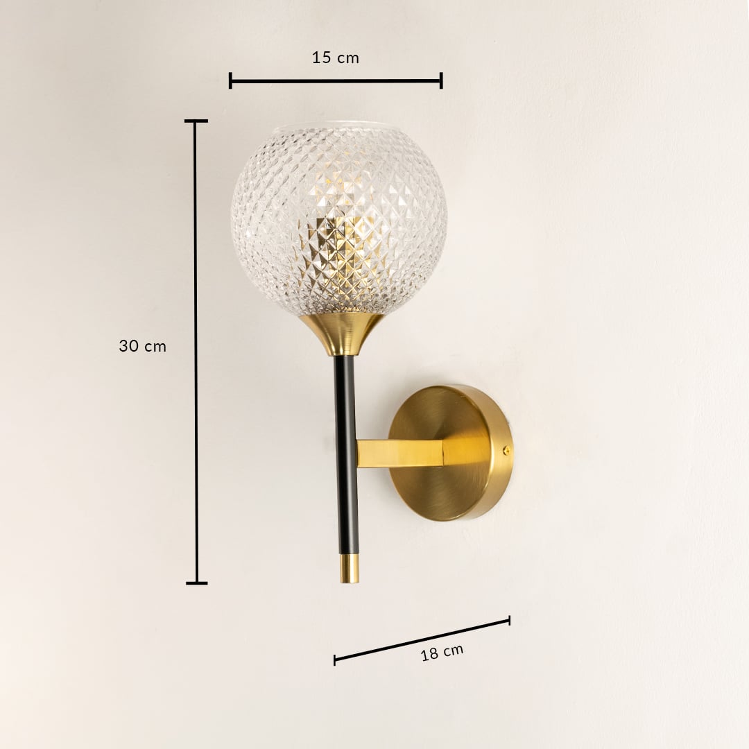 A gold and black wall sconce with a diamond cut glass globe shown with full measurements displaying a height of 30 cm a width of 15 cm and a depth of 18 cm for precise placement.