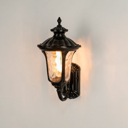 Black metal outdoor wall lantern on white background with textured water glass shade for classic entryway decor.
