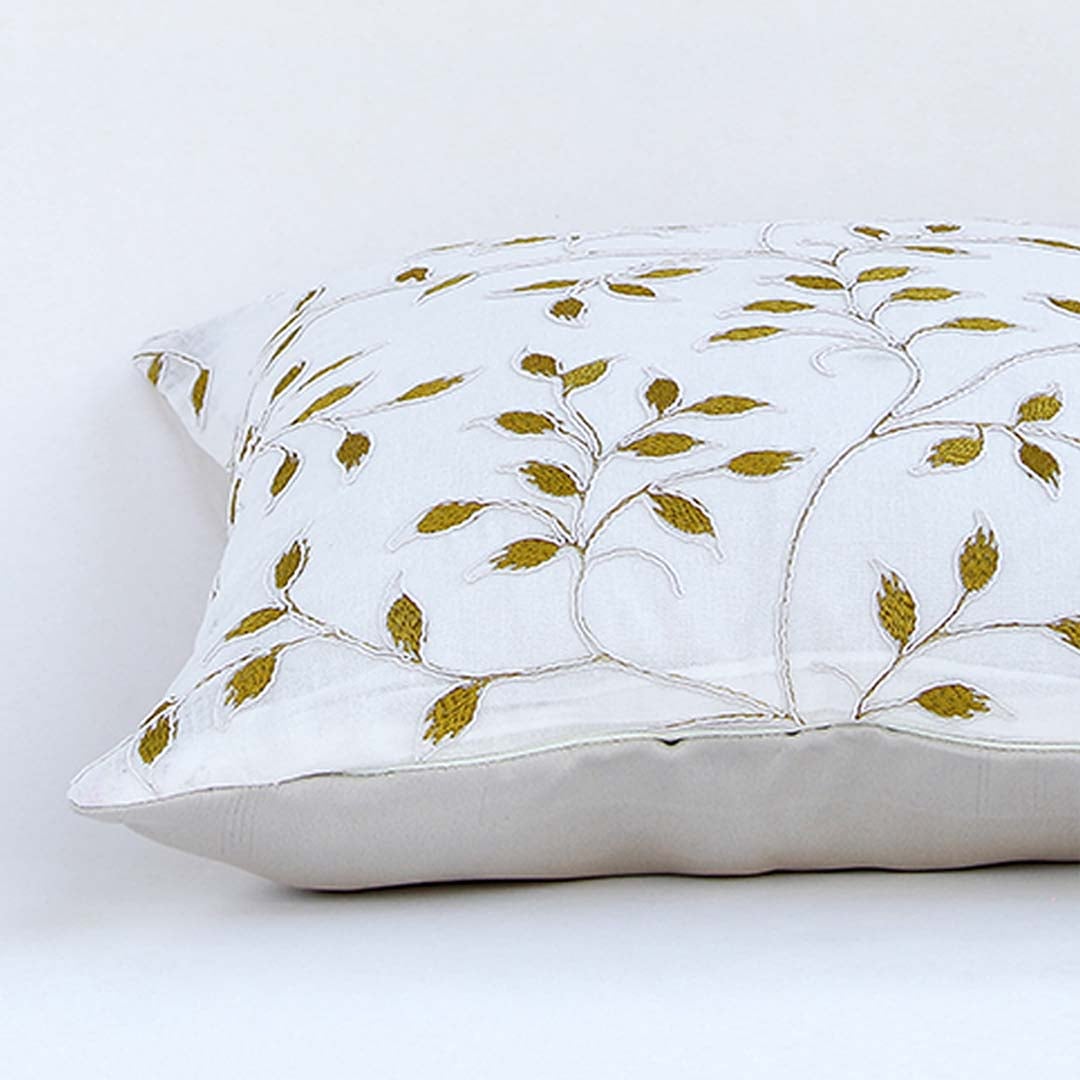 White cotton cushion cover with golden leaf embroidery in a rectangular form adding an elegant natural décor detail with a soft comfortable and skin friendly material.