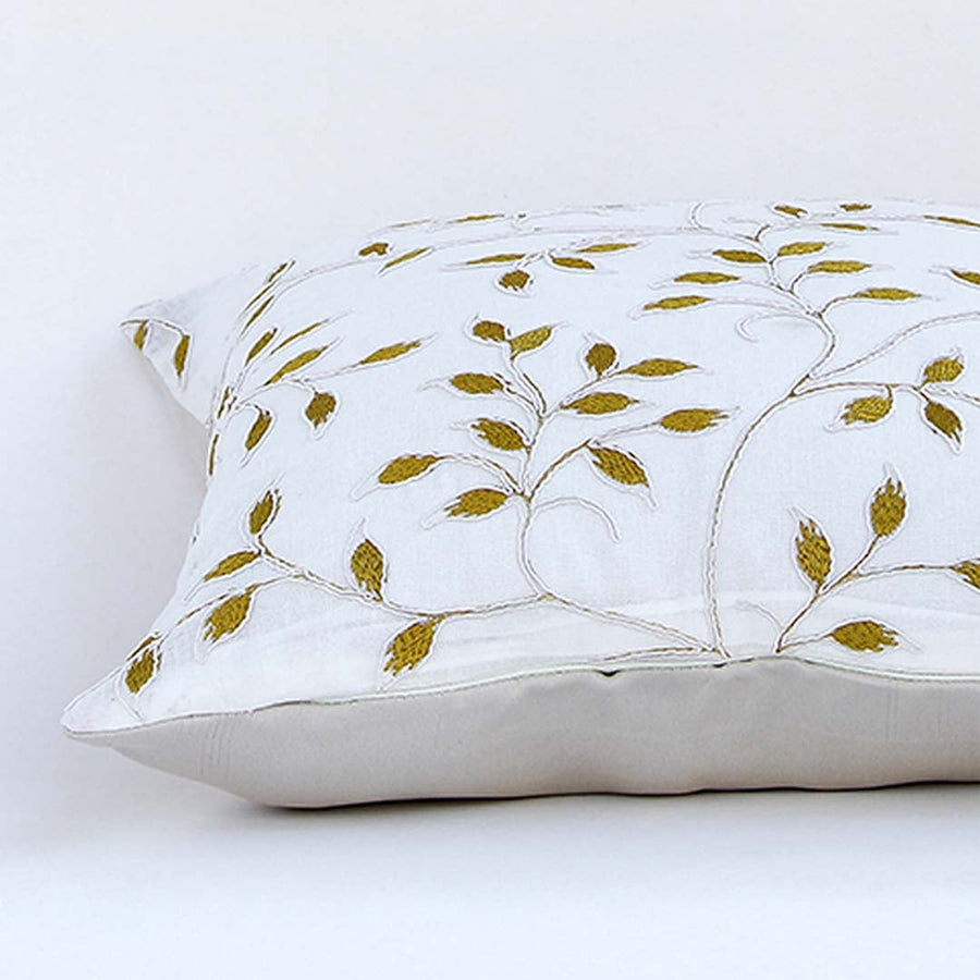 White cotton cushion cover with golden leaf embroidery in a rectangular form adding an elegant natural décor detail with a soft comfortable and skin friendly material.
