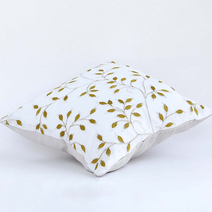 Soft cotton cushion cover with golden botanical embroidery shown at an angle offering a warm nature inspired décor accent with a breathable gentle and skin friendly fabric finish.
