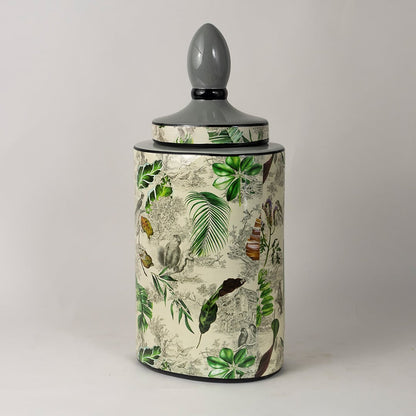 Side angle view of tropical leaf jar revealing curved surface and hand painted leaf detailing.