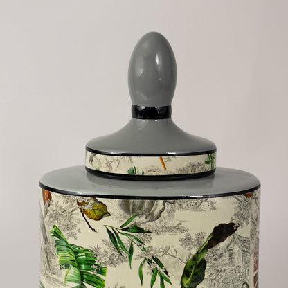 Closeup of tropical leaf jar showing hand painted green leaves and intricate artistic details.