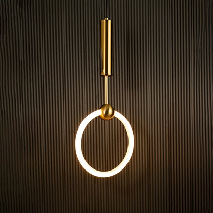 White ring pendant light with sleek metal cylinder casting warm ambient glow imagined against a dark black background creating a dramatic modern interior decor mood.