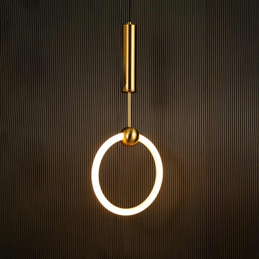 White ring pendant light with sleek metal cylinder casting warm ambient glow imagined against a dark black background creating a dramatic modern interior decor mood.