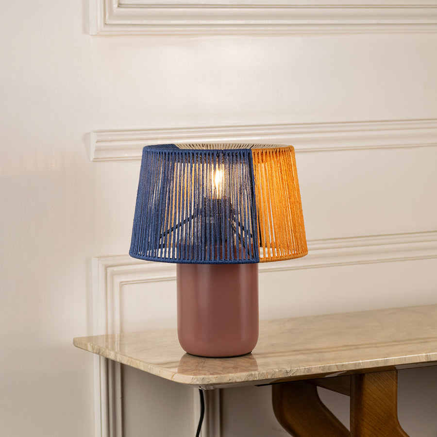 Table lamp with dual color fabric shade and ceramic base ideal for modern bedroom or living room decor on clean background.